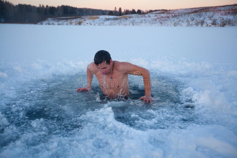 Young man having recreational swim in the ice hole. Young man having recreational swim in the ice hole