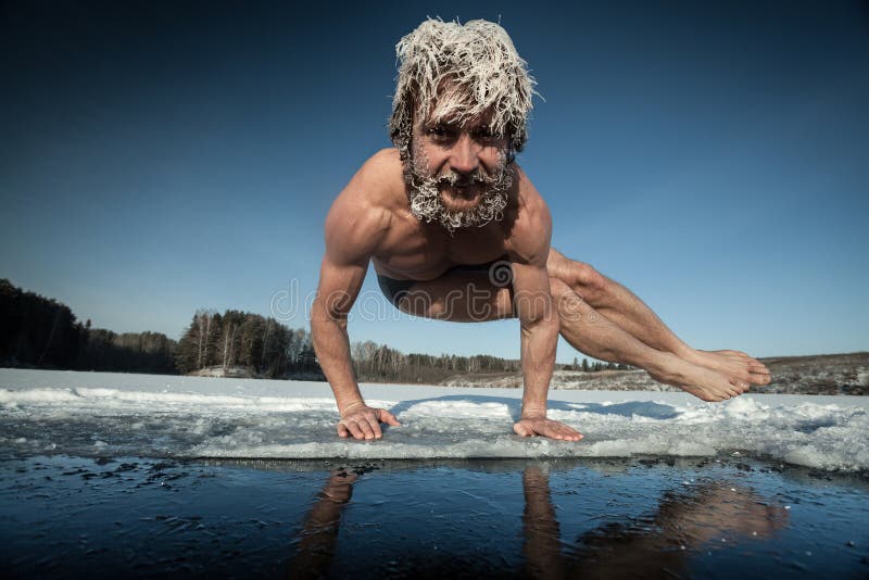 Man with frozen hair doing yoga exercise, parsva bakasana, on the ice. Man with frozen hair doing yoga exercise, parsva bakasana, on the ice