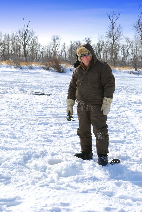 Man ice fishing on frozen river. Man ice fishing on frozen river.