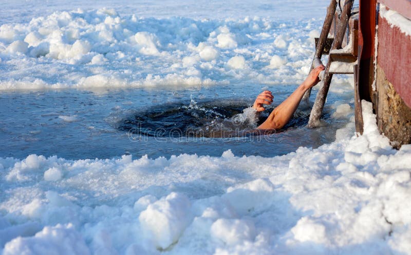 Man swimming in the ice hole at sunny day. Man swimming in the ice hole at sunny day