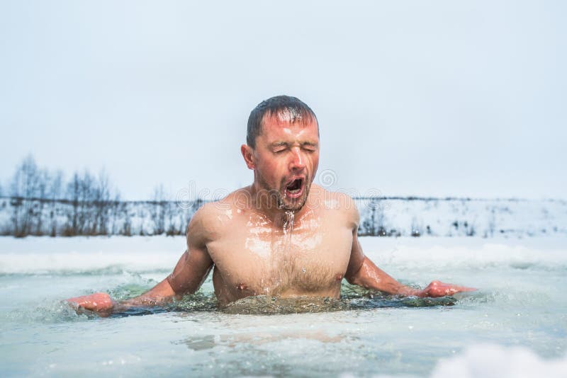 Young man swimming in the winter lake in the ice hole. Young man swimming in the winter lake in the ice hole