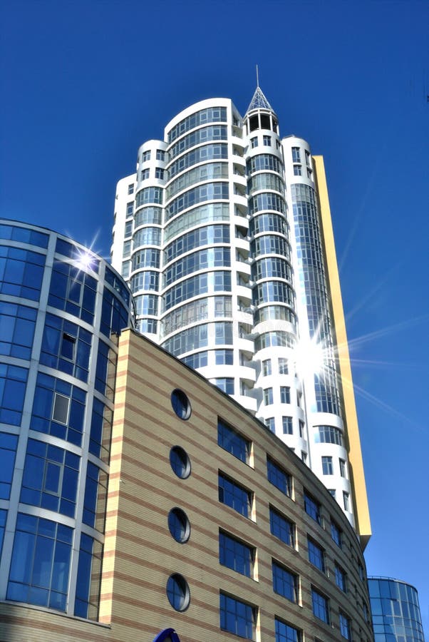 The lofty white building is against dark blue sky