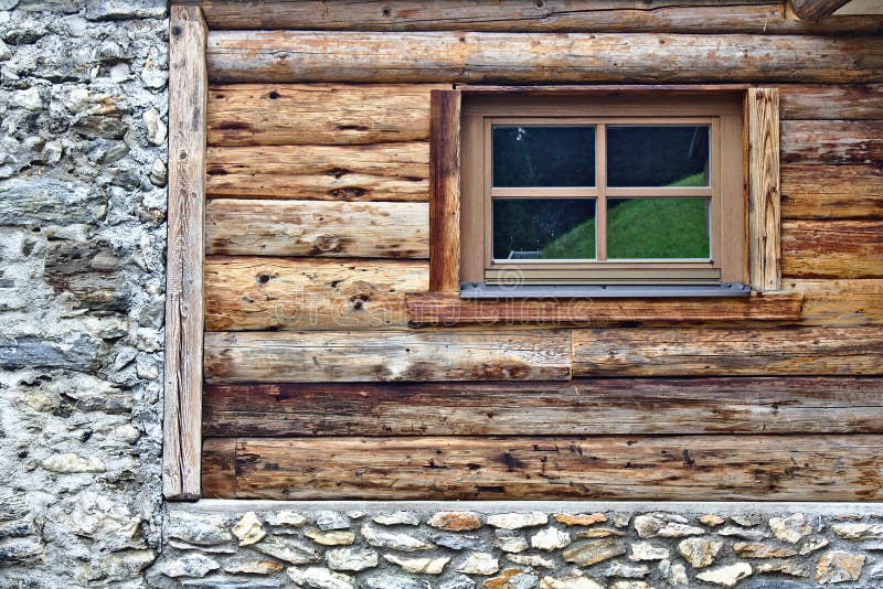 Log cabin wall with window and field stone foundation