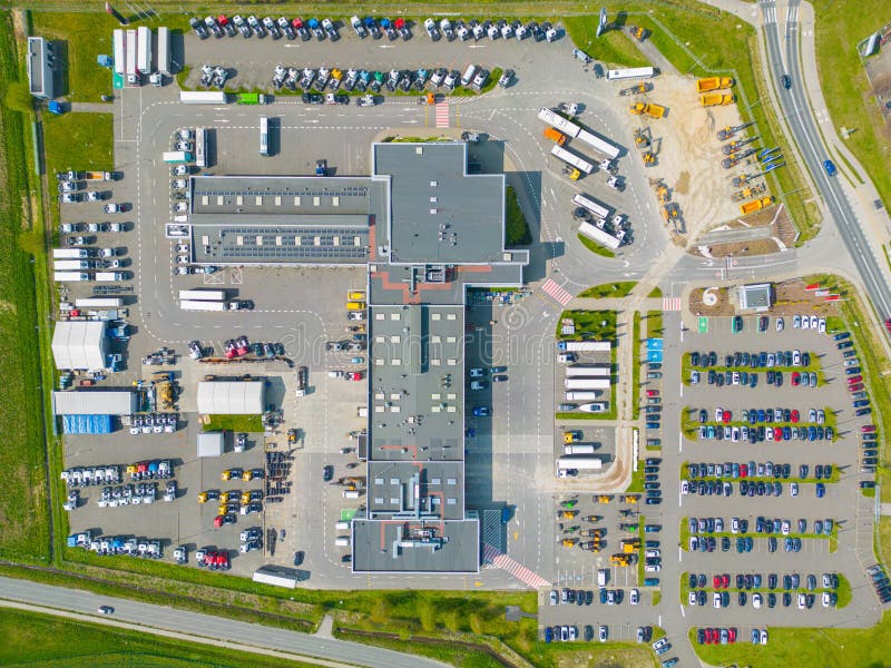 Logistics park with warehouse. Semi-trailers trucks standing on car parking and waiting for loading and unloading goods at ramps. royalty free stock photography