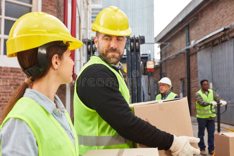 Logistics workers of a freight carrier carry packages stock photos