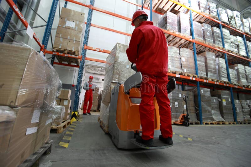 Logistics - two workers working in storehouse with forklift loader. Logistics - two workers working in storehouse with forklift loader