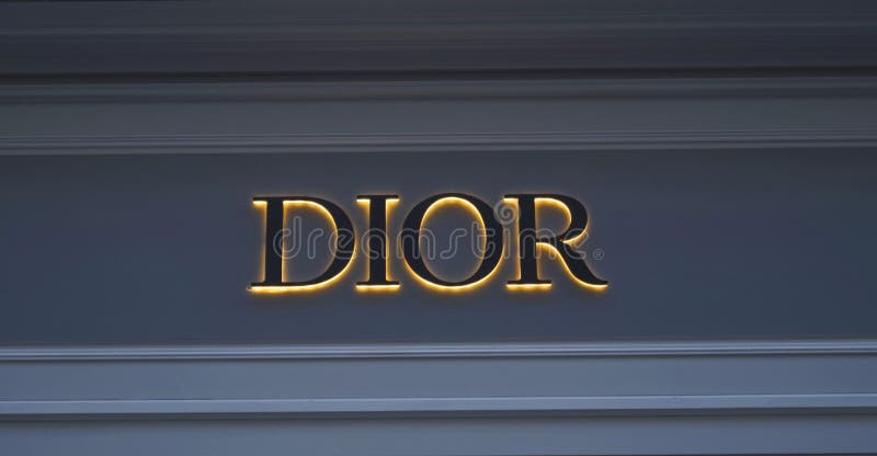 Logo rougeoyant sur la marque DIOR de mur photographie stock Logo rougeoyant sur la marque DIOR de mur photographie stock