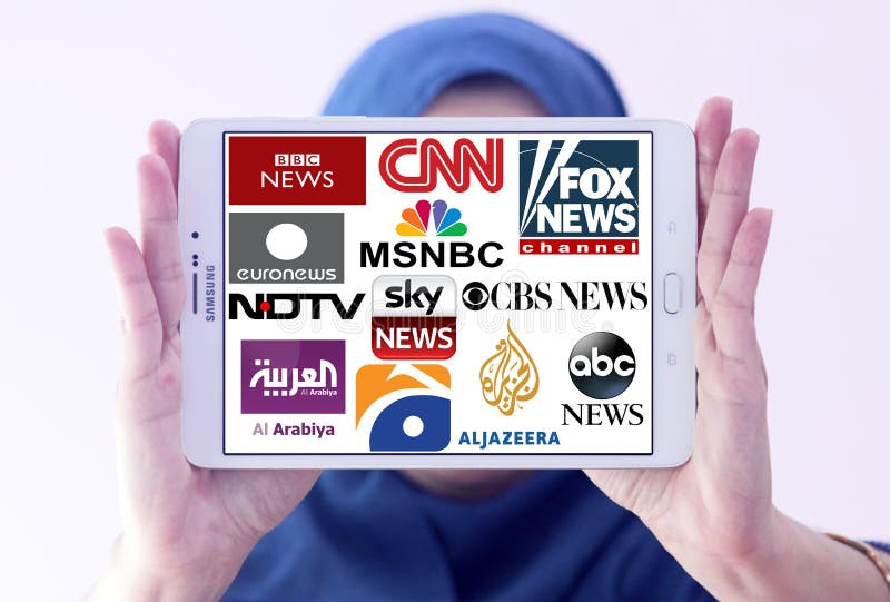 Arab muslim woman holding white tablet and logos of top famous tv news channels and networks on display. Arab muslim woman holding white tablet and logos of top famous tv news channels and networks on display