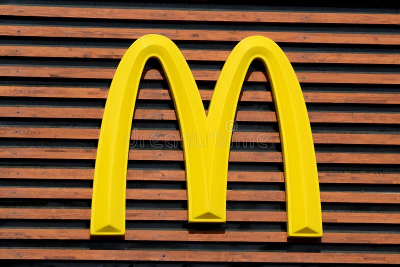 Mc Donald's Logo on a wooden background from the main restaurant in Bucharest. Mc Donald's Logo on a wooden background from the main restaurant in Bucharest