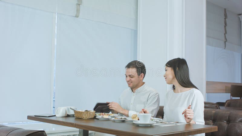 Lohnliste des glücklichen Paars, die vom Kellner geholt wird und Café verlassen ist lizenzfreie stockfotos Lohnliste des glücklichen Paars, die vom Kellner geholt wird und Café verlassen ist lizenzfreie stockfotos