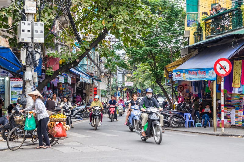Lokal dagligt liv och sikt av upptagen trafik med mopeder i Hanoi den gamla fjärdedelen, huvudstad av Vietnam Folket kan sett und