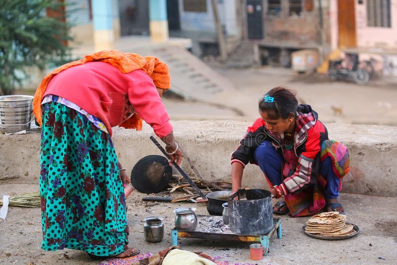 Lokala kvinnor som lagar mat chapatien i gatan av Jaipur, Rajasthan royaltyfria foton