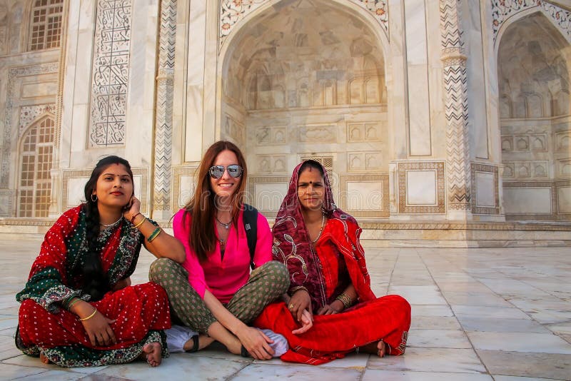 Lokalne kobiety i cudzoziemski dziewczyny obsiadanie na zewnątrz Taj Mahal w Agra
