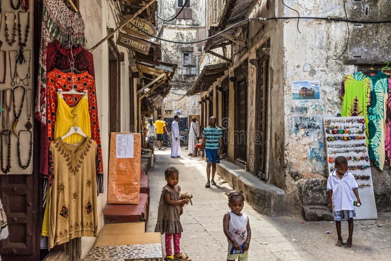 Lokalni ludzie na typowej wąskiej ulicie w Kamiennym miasteczku, Zanzibar obrazy stock Lokalni ludzie na typowej wąskiej ulicie w Kamiennym miasteczku, Zanzibar obrazy stock