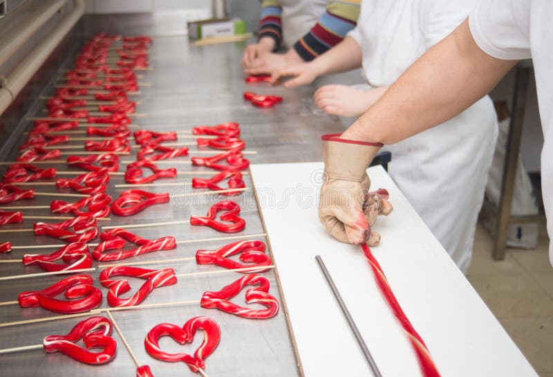 Lolly die van gesmolten suiker in traditionele suikergoedworkshop maken royalty-vrije stock afbeelding Lolly die van gesmolten suiker in traditionele suikergoedworkshop maken royalty-vrije stock afbeelding