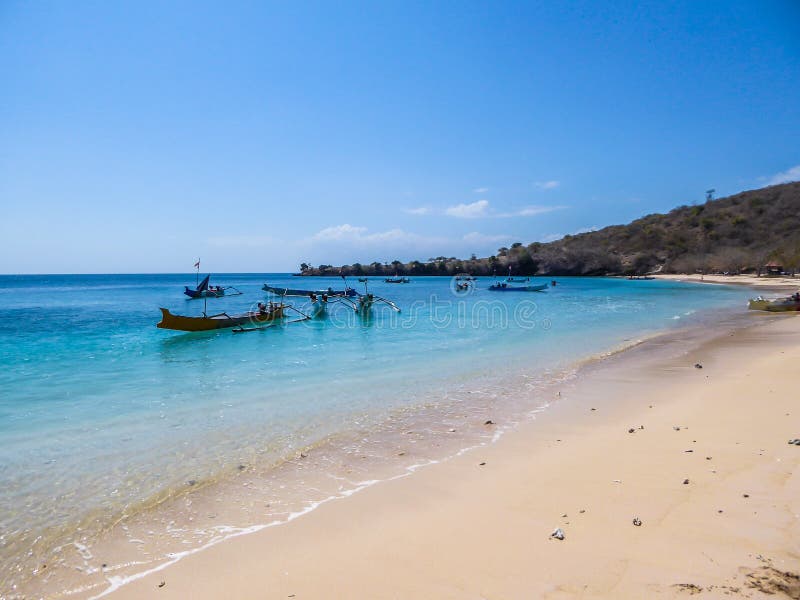 Lombok- розовый пляж с большим количеством boath, поставленным на якоре росеса стоковое фото