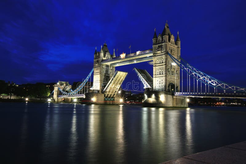 Tower bridge bei Nacht in London mit einem Boot vorbei über die Straße eröffnet.