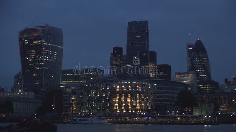 London centrum med kontorsbyggnadskyskrapor och Thames River i nattsikt