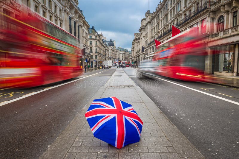 London, England - British umbrella at busy Regent Street with iconic red double-decker buses
