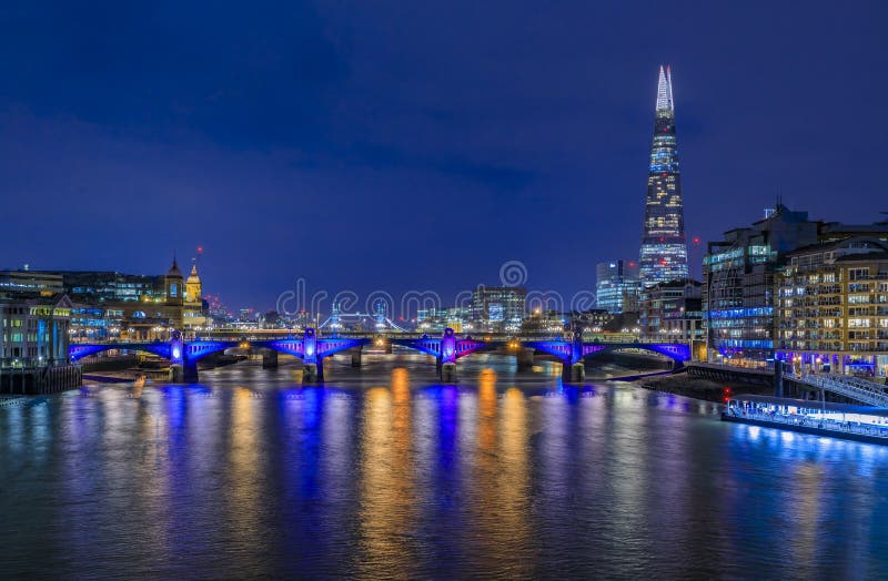 London, England skyline at night with the Shard, Southwark Bridge and Tower Bridge on Thames river with night lights