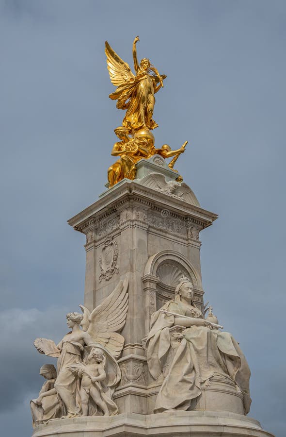 London, England, UK - July 6, 2022: Victoria Memorial. 3 statues combination: White marble Queen Victora, Golden Winged Victory, and white marble Truth under blue sky. London, England, UK - July 6, 2022: Victoria Memorial. 3 statues combination: White marble Queen Victora, Golden Winged Victory, and white marble Truth under blue sky