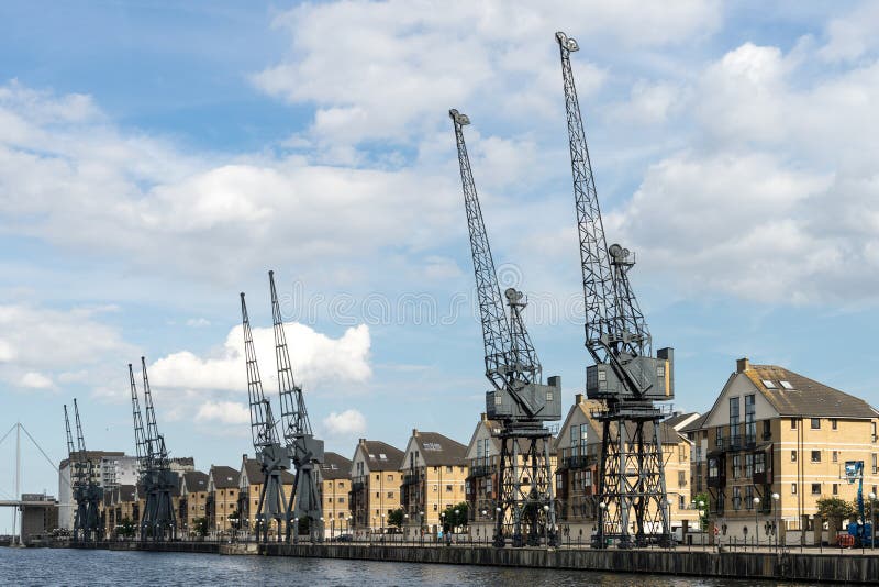 LONDON - JUNE 25 : Old dockside cranes alongside a waterfront de royalty free stock image