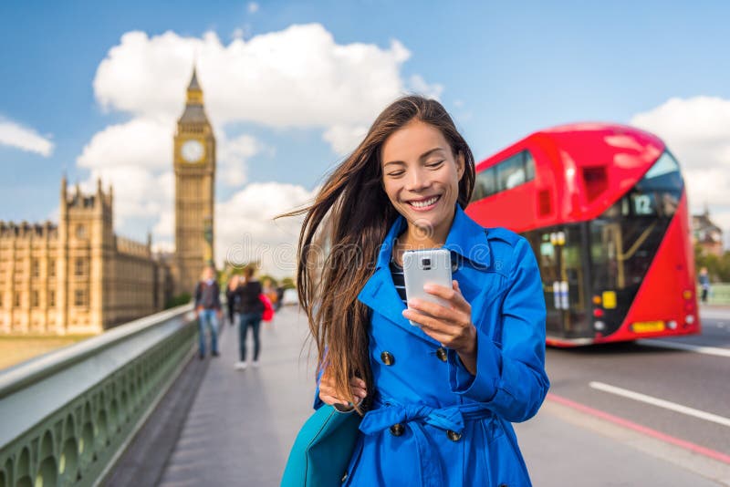 London phone business woman texting on smartphone mobile app for payment or online shopping. Urban city lifestyle Asian