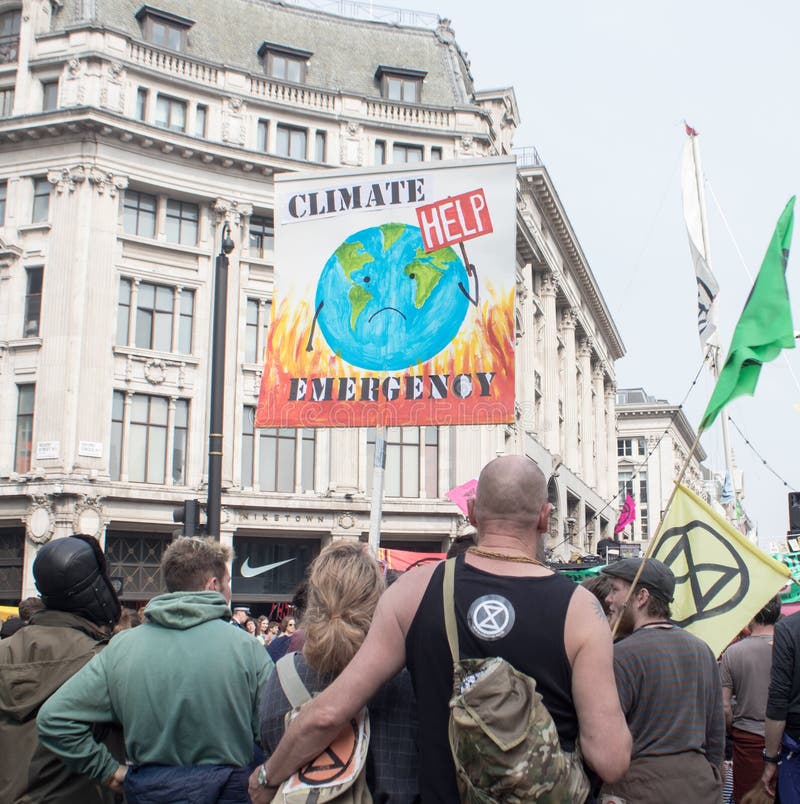 London, UK, April 17 2019 - Protesters hold a banner and flag at a climate change protest outside Oxford Circus underground