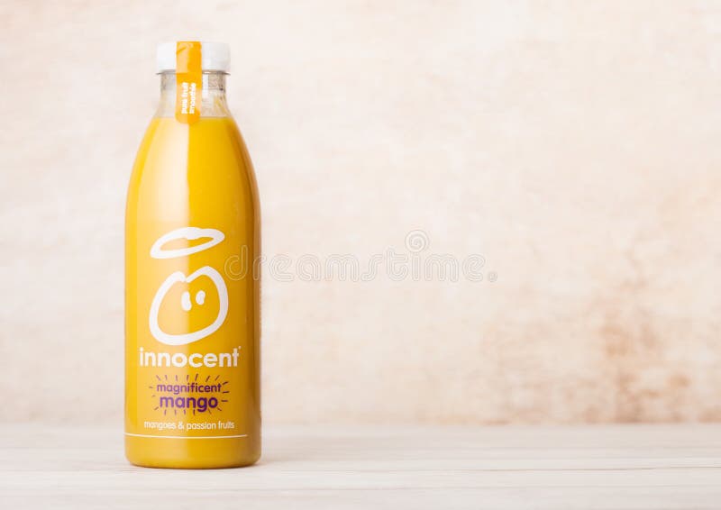 LONDON, UK - AUGUST 10, 2018: Bottle of Innocent organic smoothie juice drink with mango flavour on wooden background.