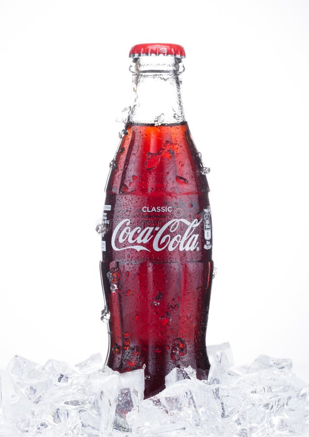 LONDON UK - JANUARI 20, 2018: Kall glasflaska av den Coca Cola drinken med is och dagg på vit Drinken produceras och manufact royaltyfri fotografi