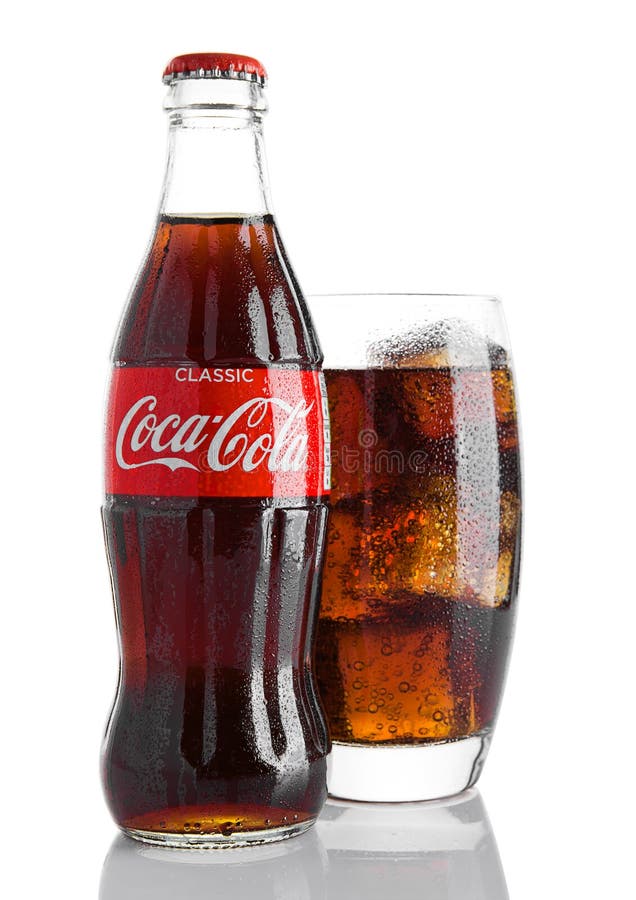 LONDON UK - NOVEMBER 07, 2016: Klassisk flaska av cocaen - cola med exponeringsglas på vit bakgrund med julleksaker och snö arkivfoton