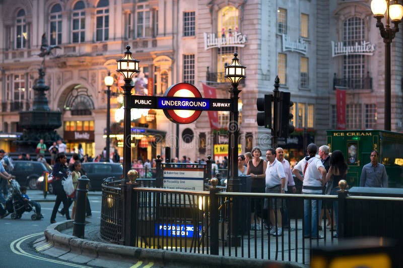 Piccadilly Circus street scene at night with underground tube station entrance in foreground, London. Piccadilly Circus street scene at night with underground tube station entrance in foreground, London.