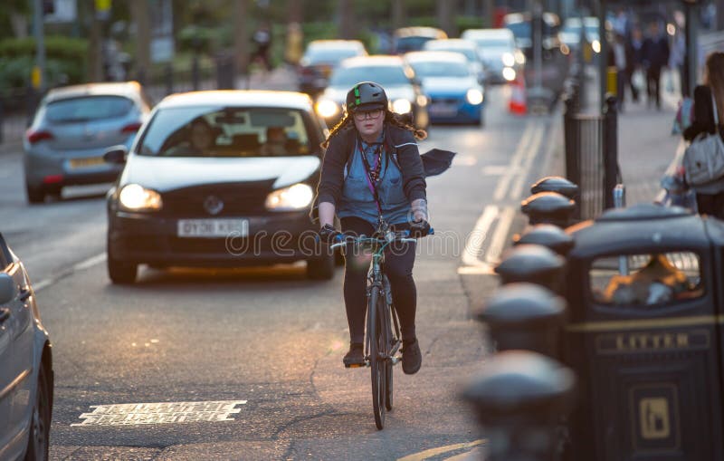 Londoners som pendlar från arbete med cykeln Vägsikt med bilar och cyklister arkivbild