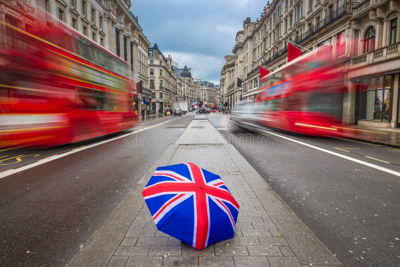 Londra, Inghilterra - ombrello britannico a Regent Street occupato con gli autobus a due piani rossi iconici fotografie stock libere da diritti Londra, Inghilterra - ombrello britannico a Regent Street occupato con gli autobus a due piani rossi iconici fotografie stock libere da diritti