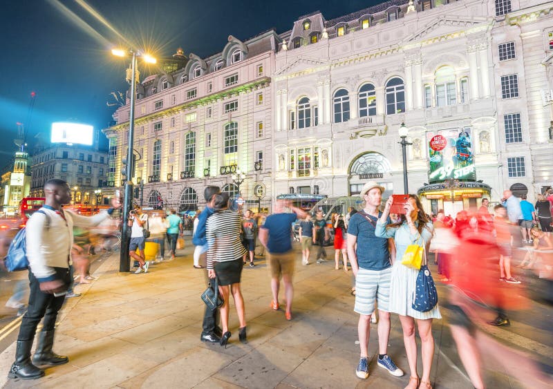 LONDRES - EM JUNHO DE 2015: Turistas no circo de Piccadilly na noite Lond fotos de stock LONDRES - EM JUNHO DE 2015: Turistas no circo de Piccadilly na noite Lond fotos de stock