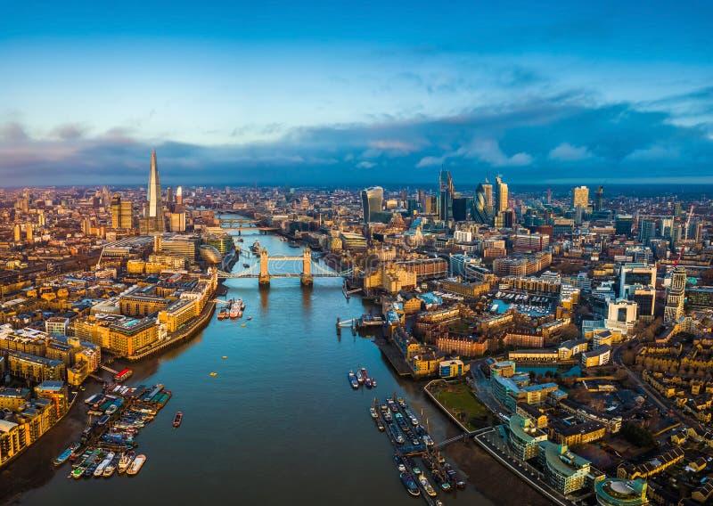 London, England - Panoramic aerial skyline view of London including Tower Bridge with red double-decker bus, Tower of London, skyscrapers of Bank District and other famous skyscrapers at golden hour. London, England - Panoramic aerial skyline view of London including Tower Bridge with red double-decker bus, Tower of London, skyscrapers of Bank District and other famous skyscrapers at golden hour