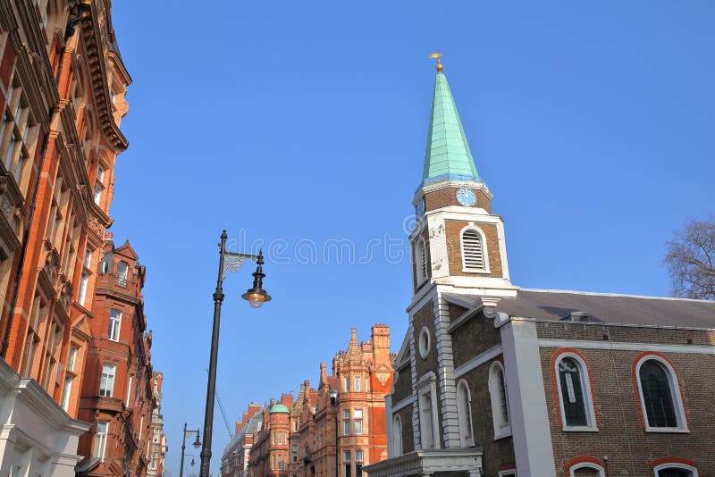 LONDRES, REINO UNIDO: Capilla de Grosvenor y fachadas victorianas de las casas del ladrillo rojo en la ciudad de la calle de S Au imagenes de archivo LONDRES, REINO UNIDO: Capilla de Grosvenor y fachadas victorianas de las casas del ladrillo rojo en la ciudad de la calle de S Au imagenes de archivo