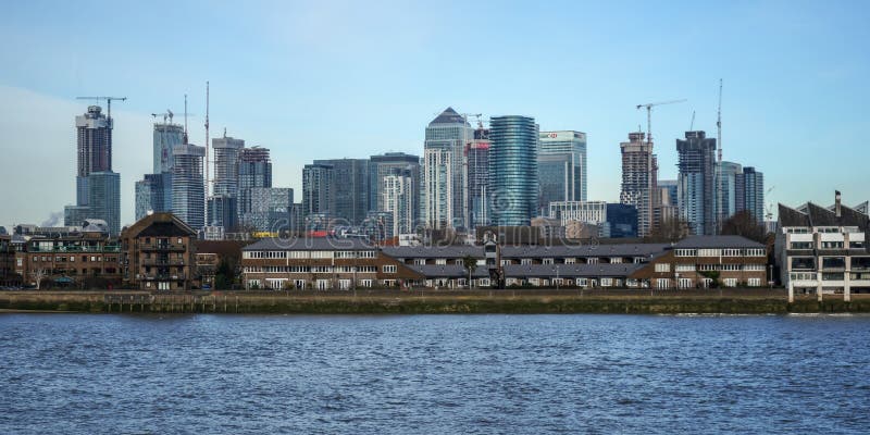 Londres, Reino Unido - 3 de fevereiro de 2019: Vista sobre o rio Tamisa em Canary Wharf, distrito financeiro principal, com fotografia de stock royalty free Londres, Reino Unido - 3 de fevereiro de 2019: Vista sobre o rio Tamisa em Canary Wharf, distrito financeiro principal, com fotografia de stock royalty free