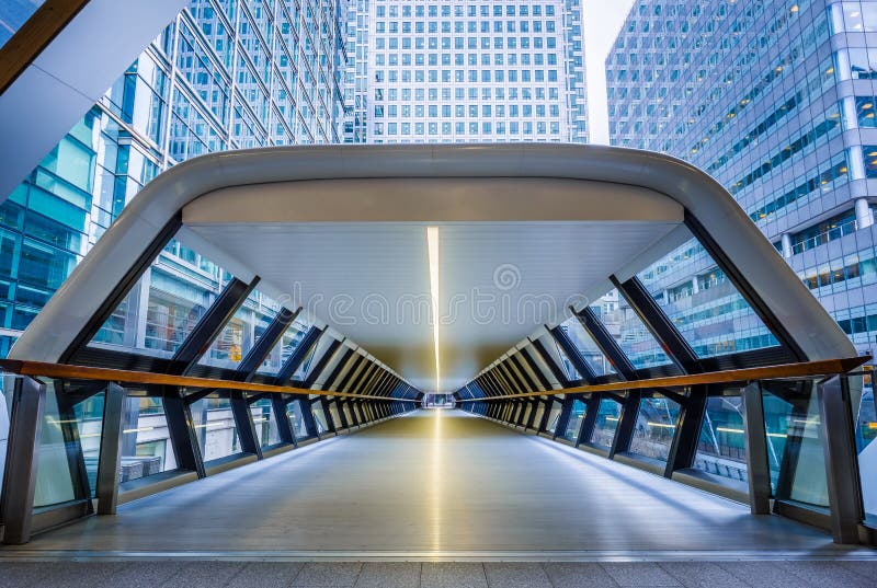 London, England - Public pedestrian cross rail footbridge at the financial district of Canary Wharf with skyscrapers. London, England - Public pedestrian cross rail footbridge at the financial district of Canary Wharf with skyscrapers