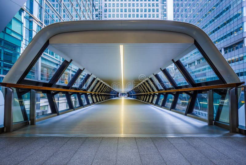 London, England - Public pedestrian cross rail footbridge at the financial district of Canary Wharf with skyscrapers. London, England - Public pedestrian cross rail footbridge at the financial district of Canary Wharf with skyscrapers