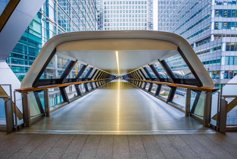 London, England - Public pedestrian cross rail footbridge at the financial district of Canary Wharf with skyscrapers. London, England - Public pedestrian cross rail footbridge at the financial district of Canary Wharf with skyscrapers