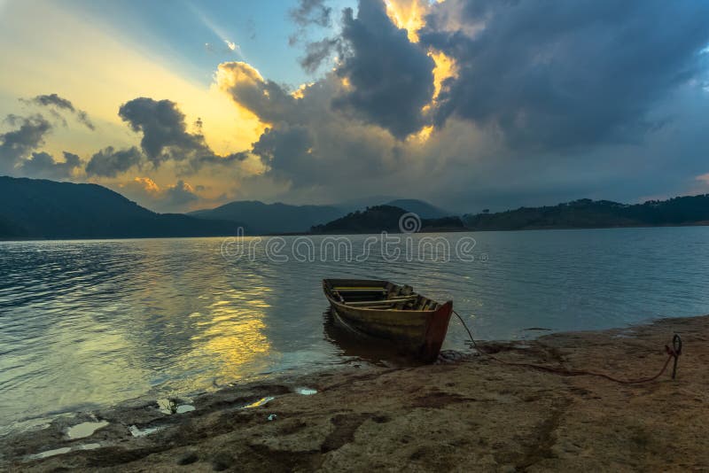 A lone boat in the shore of umiam lake during sunset time