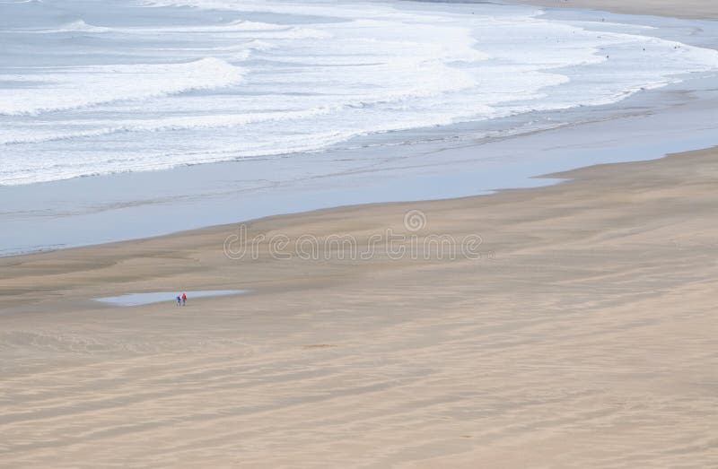 Lone couple walking along deserted beach