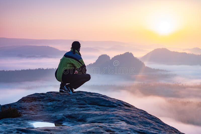 Lone person sit looks onwards at a mountain