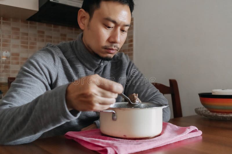 Lonely man having a meal alone in his home.