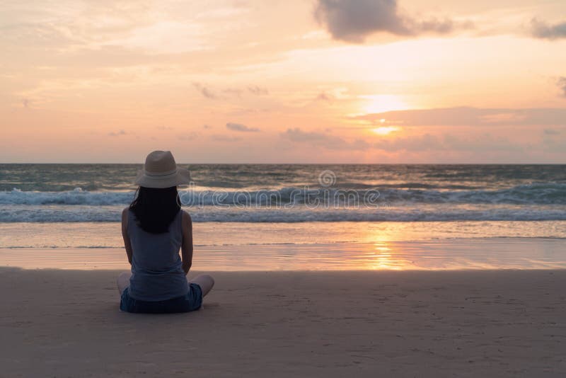 Lonely Asian woman thinking about problems and suffering at the beach during travel holidays vacation outdoors at ocean or nature