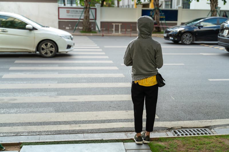 Lonely girl with hooded clothe in the city. Alone girl in danger concept.