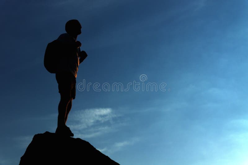 Lonely male hiker standing on the mountain top