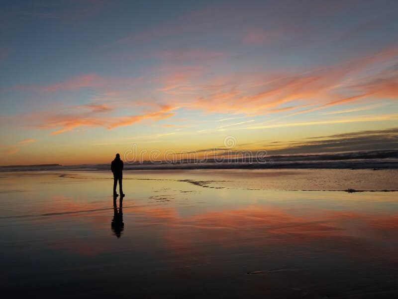 Lonely man watching the sunset on the beach