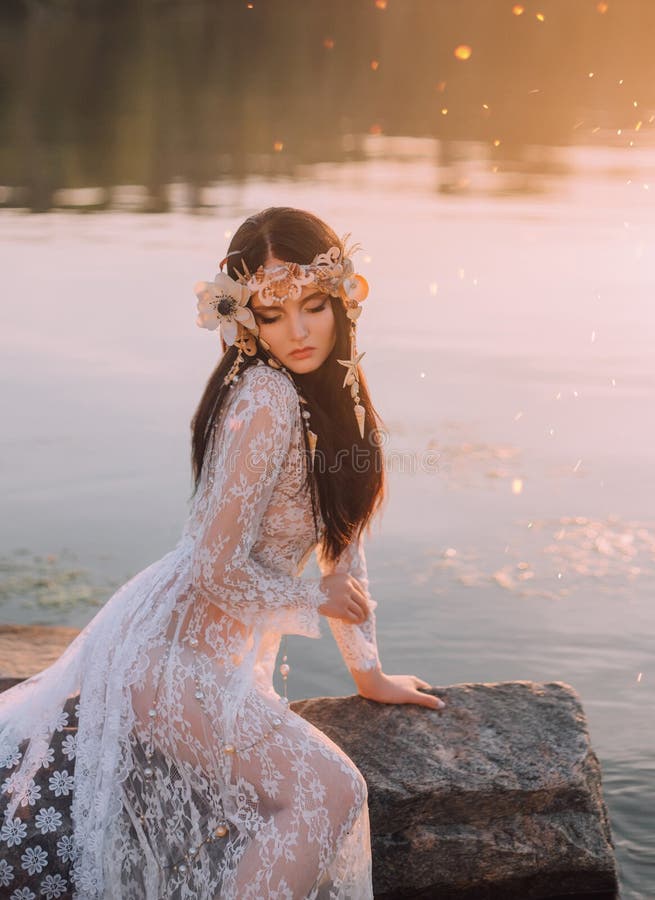 A lonely mermaid, sitting on a rock in the middle of the river, which was tightened by a thick, impenetrable fog. On the sea nymph a white vintage dress with bare legs and a wreath of shells